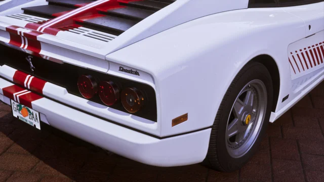 Details of the taillights, the make and model logos, and the license plate of a white Grotti Cheetah with a minimalist, retro-futuristic livery.