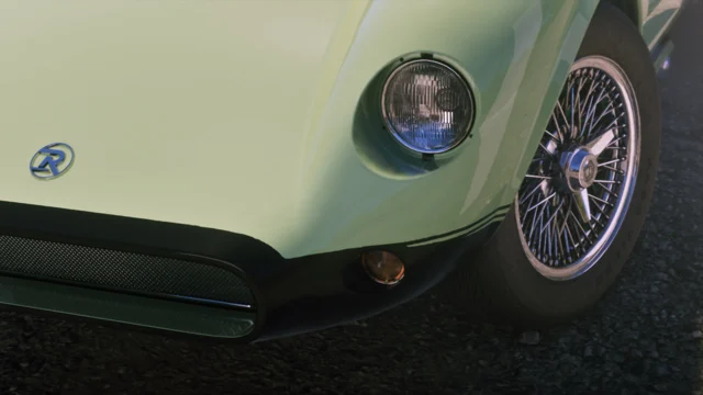 Close up view of the front of a classic green sports car.